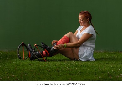 Red haired latin woman getting ready to do a workout routine while putting on kangoo jumps boots