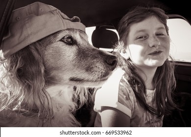 Red Haired Pet Dog Wearing Baseball Cap Hanging Out In A Car With Its Red Haired Kid Owner 