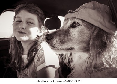 Red Haired Pet Dog Wearing Baseball Cap Hanging Out In A Car With Its Red Haired Kid Owner 