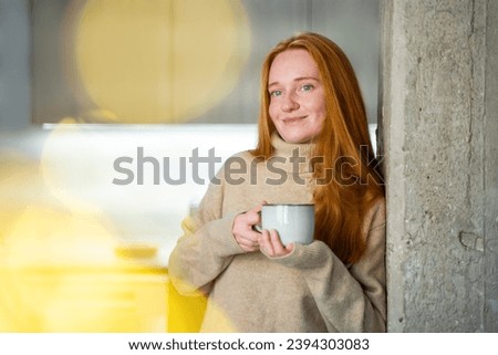 Red haired young woman wear cosy warm favorite sweater at home. Mother drinking warm tea with herbals, while baby is sleeping. Candid moment of relaxation and tranquility. Enjoying real moment.