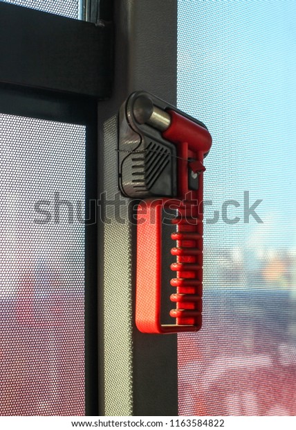 Red hammer, for breaking the window\
during emergency evacuation, on public bus\
window.