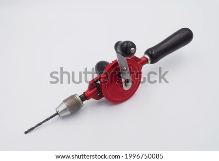 Red hand crank drill with black handle on white background