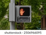 Red hand stop stop pedestrian crossing sign near Jefferson street crossroad in Downtown Portland, Oregon