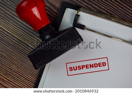 Red Handle Rubber Stamper and Suspended text isolated on White Background.