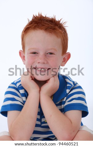 Red head boy wearing blue striped shirt with happy and smiling expression on face