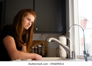 Red Head Caucasian Adult Mom Women Sad Depressed Hopeless Grief Anxiety Looking Out A Window From Kitchen