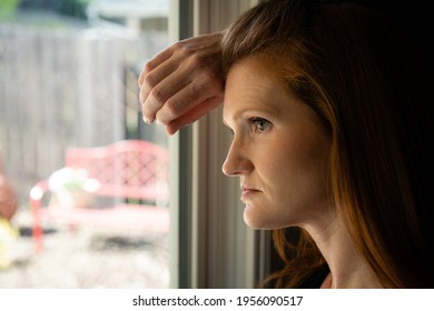 Red Head Caucasian Adult Mom Women Sad Depressed Hopeless Grief Anxiety Looking Out A Window From Kitchen