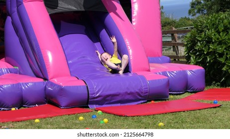 Red headed boy having fun playing on a bouncy castle - Shutterstock ID 2125664798