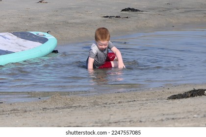 Red headed boy playing on a sandy beach in Northern Ireland Holidays in UK - Shutterstock ID 2247557085