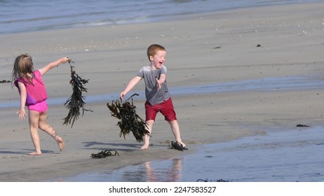 Red headed boy playing on a sandy beach in Northern Ireland Holidays in UK - Shutterstock ID 2247583527