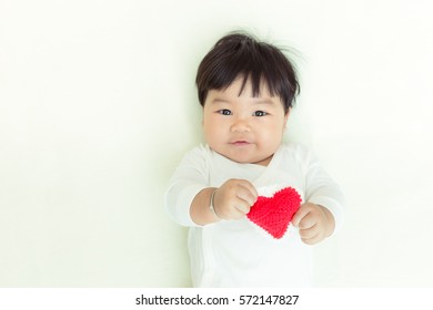 Red Heart With Adorable Asian Baby Girl For Valentine Concept Background And Copy Space.