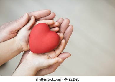 Red Heart In Child Kid And Grandmother Hands On The Grey Background