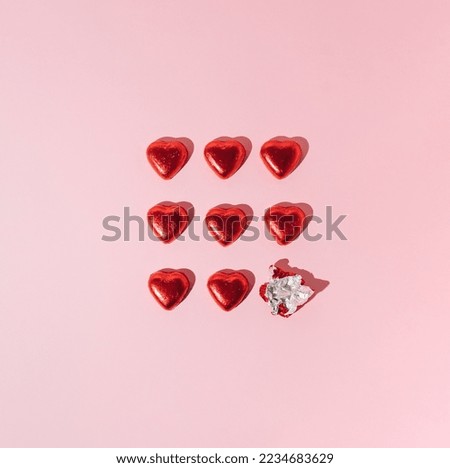 Red heart chocolates on pink background. Creative Valentines or love minimal concept.