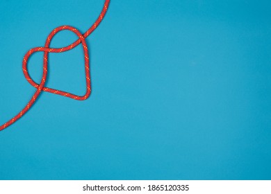 Red Heart With Climbing Rope On Blue Background