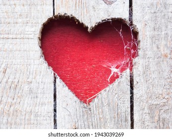 red heart cutout in wooden door with spider web - Powered by Shutterstock