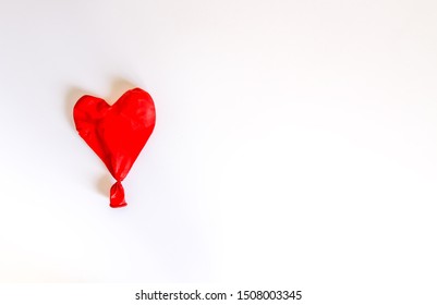 Red Heart Deflated Balloon On White Background. Celebration Accessory. 