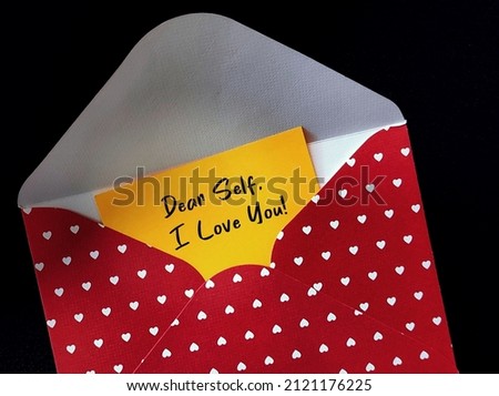 Red heart envelope with handwritten card DEAR SELF, I LOVE YOU - concept of single person writing love letter to themselves on Valentines Day