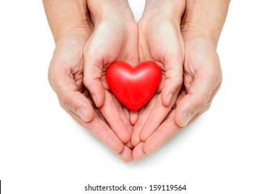 Red heart at the human hands isolated on white