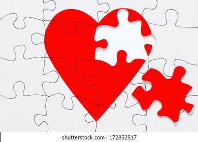 A red heart jigsaw puzzle with a piece on the side, good image for a broken heart, love, romance and Valentine themes.