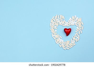 A red heart lies in a heart made of pills. Medicine and healthcare concept - Shutterstock ID 1902429778