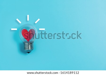 Red heart in light bulb on blue background with copy space. Valentine's day, Creative idea, Inspiration Concept.