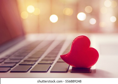 Red heart on the computer keyboard with sunlight and shadow. Internet dating, copyspace, Valentines day concept.