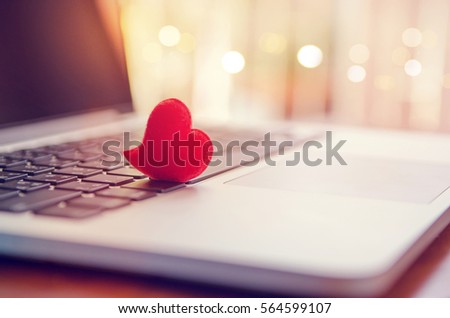 Red heart on the computer keyboard with sunlight and shadow. Internet dating, copyspace, Valentines day concept.