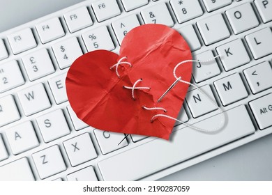 Red Heart Paper On Keyboard Computer Background. Online Internet Romance Scam Or Swindler In Website Application Dating Concept. Love Is Bait Or Victim.