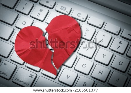 Red heart paper on keyboard computer background. Online internet romance scam or swindler in website application dating concept. Love is bait or victim.