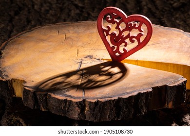 red heart with a pattern on a cracked sawn tree with bark, close-up