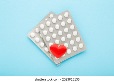 Red Heart Shape And Blister Packs Of Pills On Light Blue Table Background. Pastel Color. Closeup. Medical, Pharmacy And Healthcare Concept. 