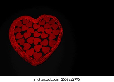 Red heart shape made of small felt hearts on a black background - Powered by Shutterstock