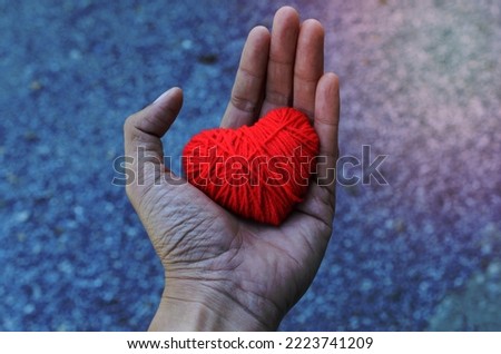 Red heart shape made from thread yarn on Hand for Love Valentine's day