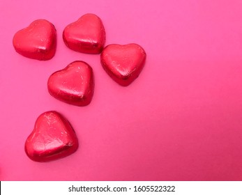 Red heart shaped chocolate candies, top view. Gentle cute gift and dessert treat by February 14, Valentine's Day, a sweet gift for lovers
