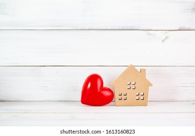 Red Heart Shaped with Home over white wood background. Symbol for love , family concept with copy space.