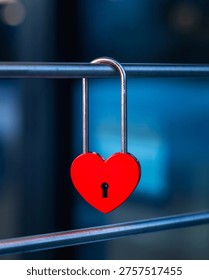 A Red Heart Shaped Lock on a Fence with a Blue Background