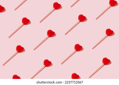 Red heart shaped lollipops pattern on pastel background. Minimal Valentine or love concept.