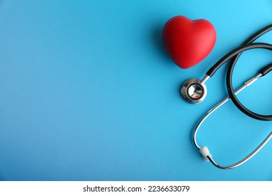  red heart and stethoscope are on blue background top view with copy space