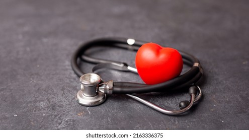 Red heart with stethoscope on dark background, heart health, health insurance concept, World heart day, world health day, doctor day, world hypertension day