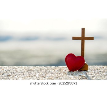 Red heart with wooden Christian cross on gravel floor in morning light, beach sea as background. Jesus love you. Faith hope believe in God. Believe in salvation. Christianity background concept. - Shutterstock ID 2025298391