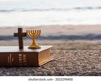 Red Heart With Wooden Christian Cross On Gravel Floor In Morning Light, Beach Sea As Background. Jesus Love You. Faith Hope Believe In God. Believe In Salvation. Christianity Background Concept.