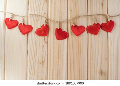 red hearts decoration hanging on a rope, wooden background. Valentine's Day. Place for text. - Powered by Shutterstock