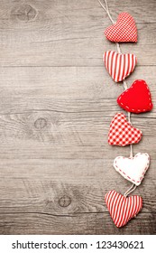 Red hearts hanging over grey wood background