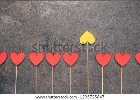 Red hearts made of paper placed on sticks and one yellow heart. Difference or individuality. It is worth having your opinion. Stand out from the crowd and different creative idea concepts.
