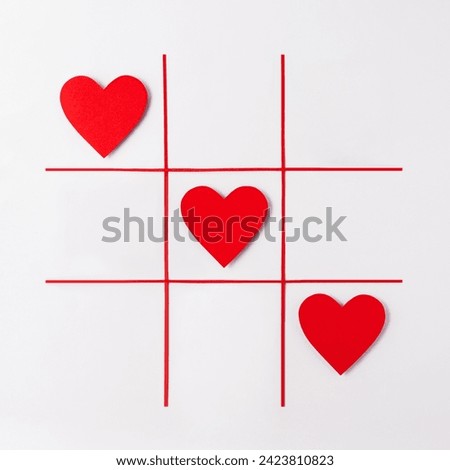 Red hearts on white background. Creative concept idea with red hearts on tic tac toe game. Valentines day concept, top view