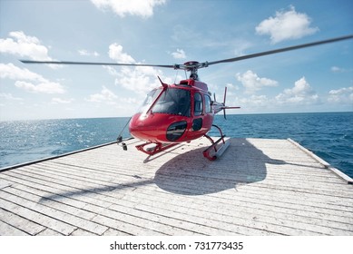 Red Helicopter on a Floating Helipad in the Great Barrier Reef near Cairns, Queensland, Australia - Powered by Shutterstock