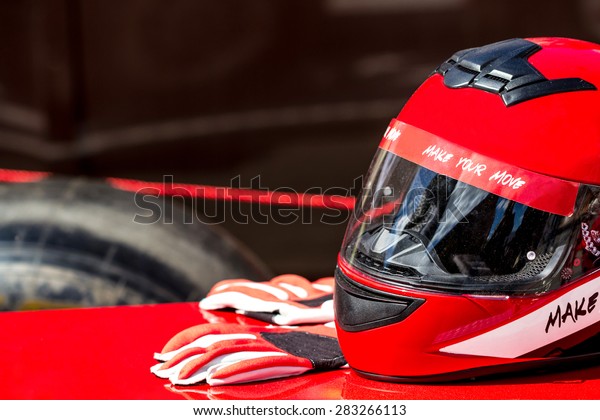 Red helmet\
with gloves for riding on a racing\
car