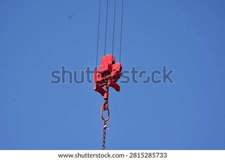 Red hook block and hook hanging from crane