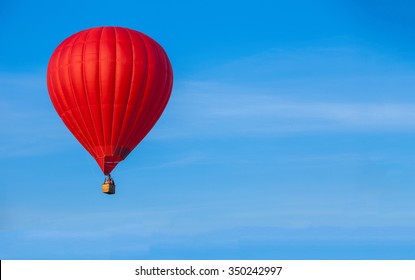 Red Hot Air Balloon In Blue Sky With White Clouds