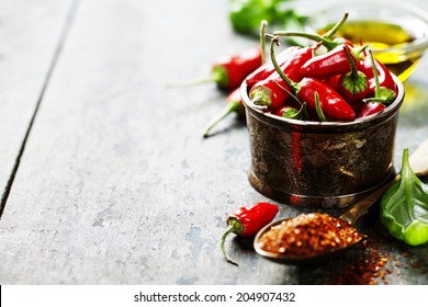 Red Hot Chili Peppers with herbs and spices over wooden background - cooking or spicy food concept - Shutterstock ID 204907432